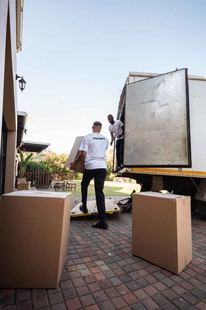 A man standing next to a moving truck.